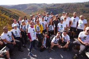Group picture of participants in a hike standing in front of a beautiful mountain scenery
